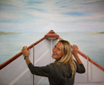Artist posing in front of boat painting